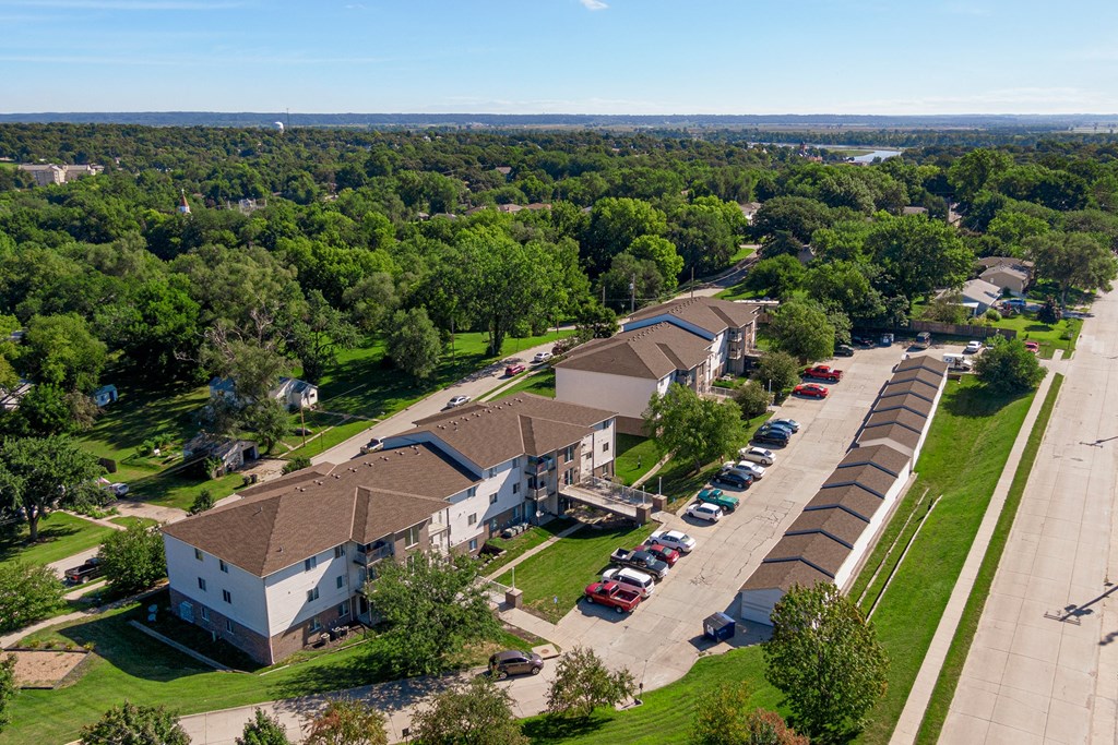 an aerial view of a building with cars parked in a parking lot