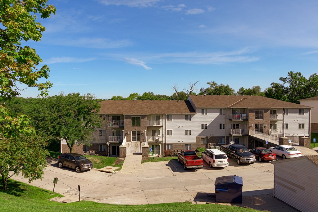 an aerial view of an apartment building with cars parked in front of it