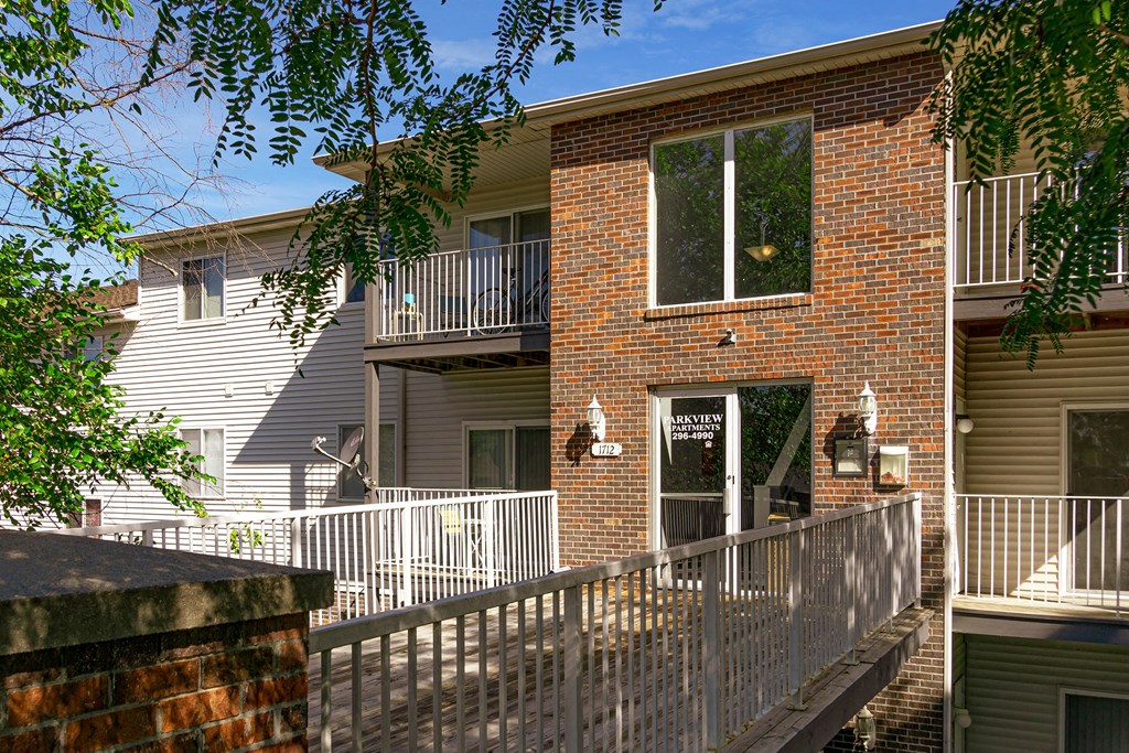 an apartment building with a balcony and a wooden deck