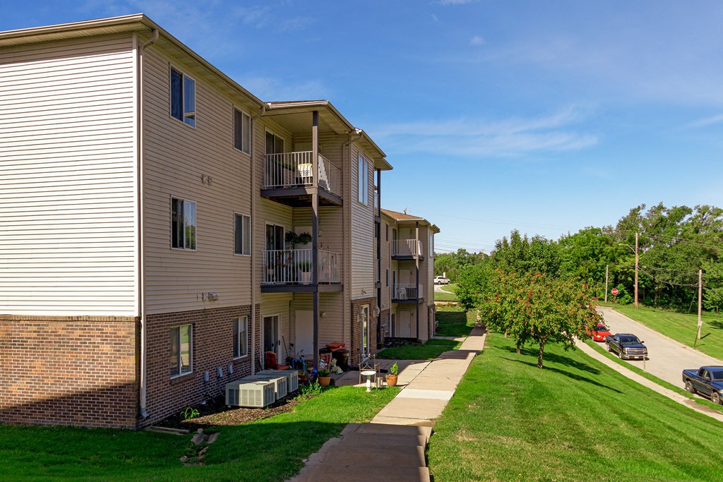 an apartment building with a sidewalk in front of it