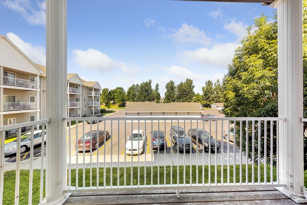 a view of the parking lot of an apartment complex with cars