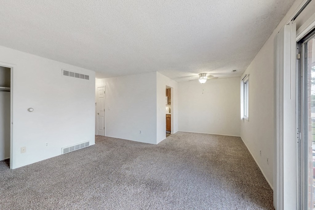 an empty living room with white walls and a carpeted floor