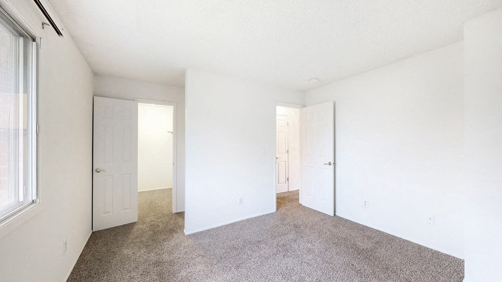 an empty room with white walls and a carpeted floor