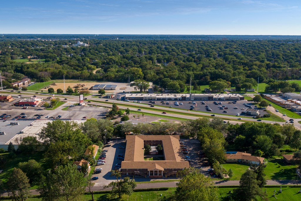 an aerial view of a parking lot with cars and a building