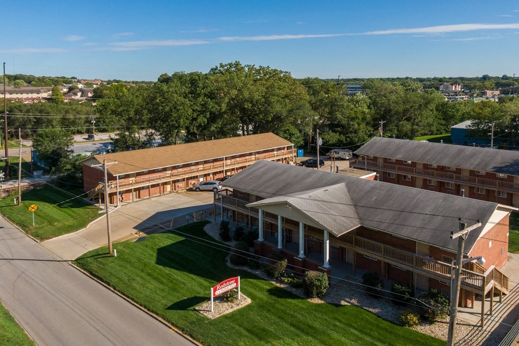 an aerial view of a building with green grass and trees