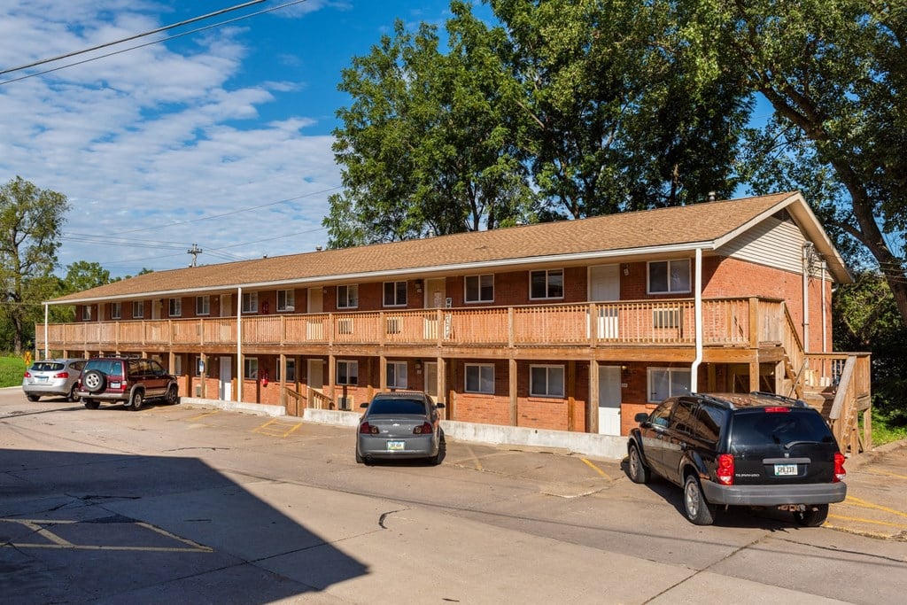 the front of a building with cars parked in a parking lot
