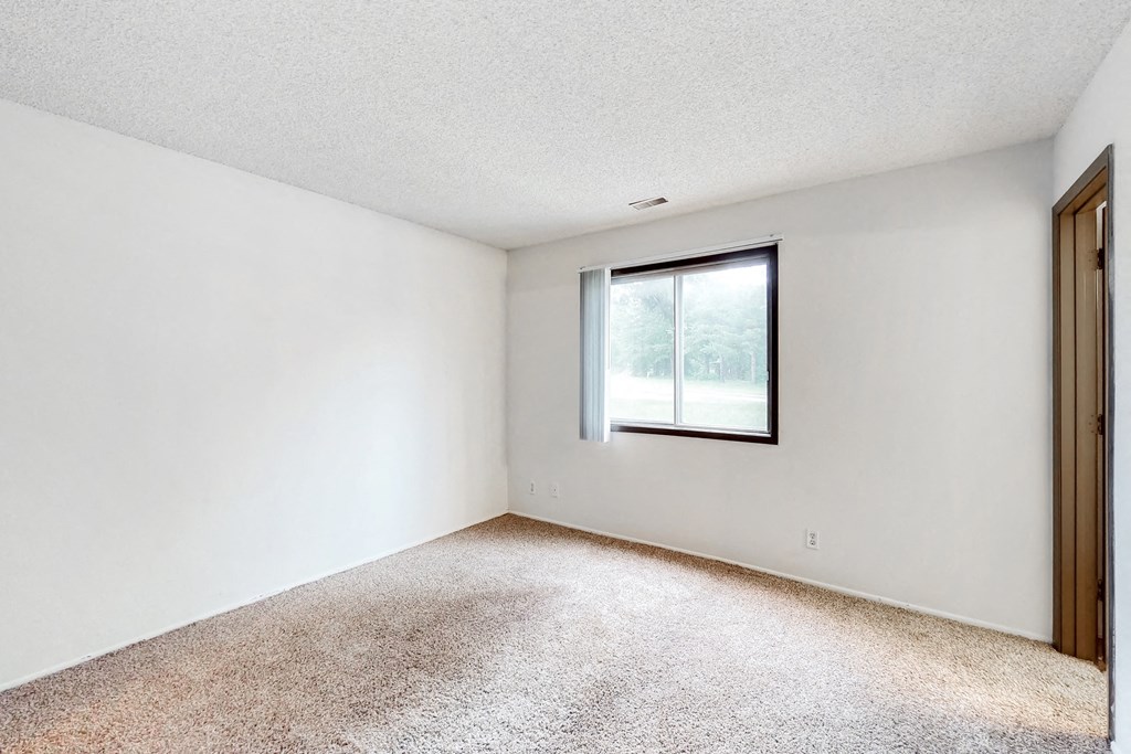 an empty room with a window and a door