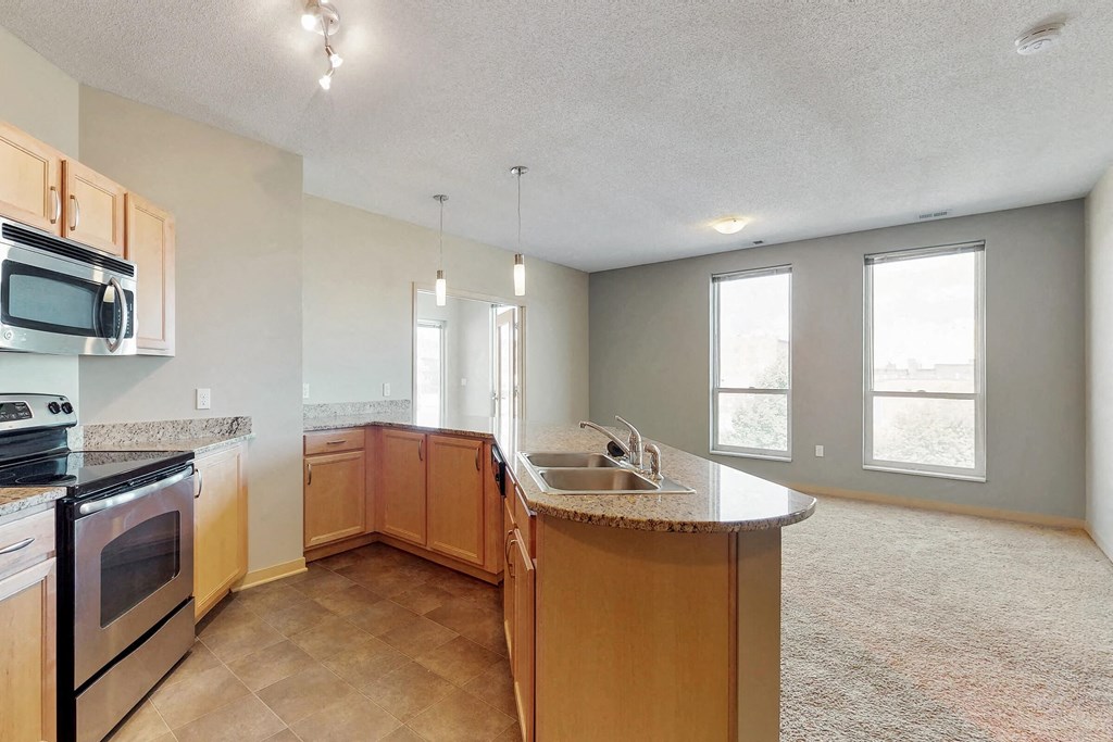 an empty kitchen with a sink and a counter top