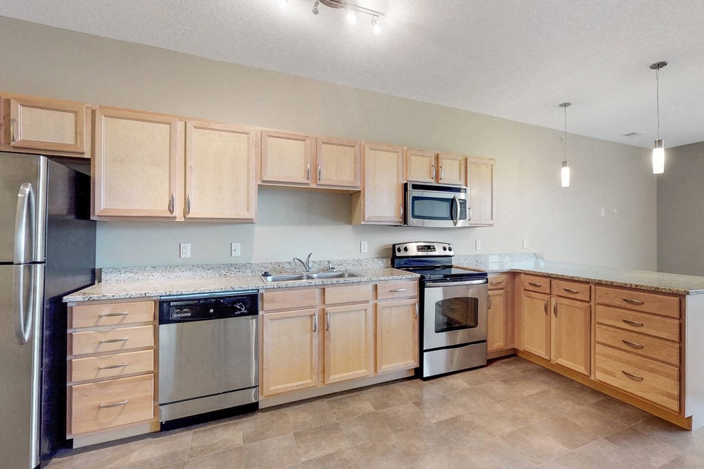 a kitchen with wooden cabinets and stainless steel appliances