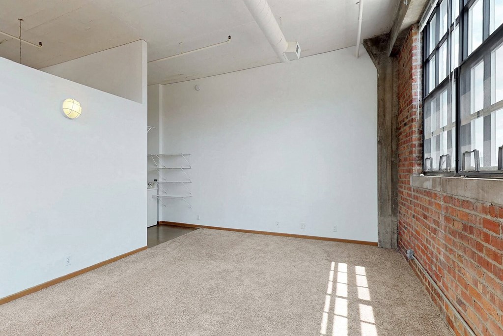 an empty room with large windows and a white wall