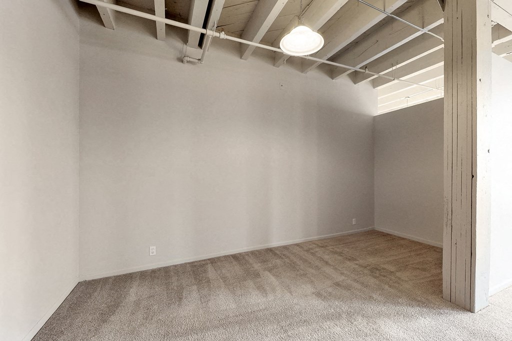 an empty room with white walls and a wood floor