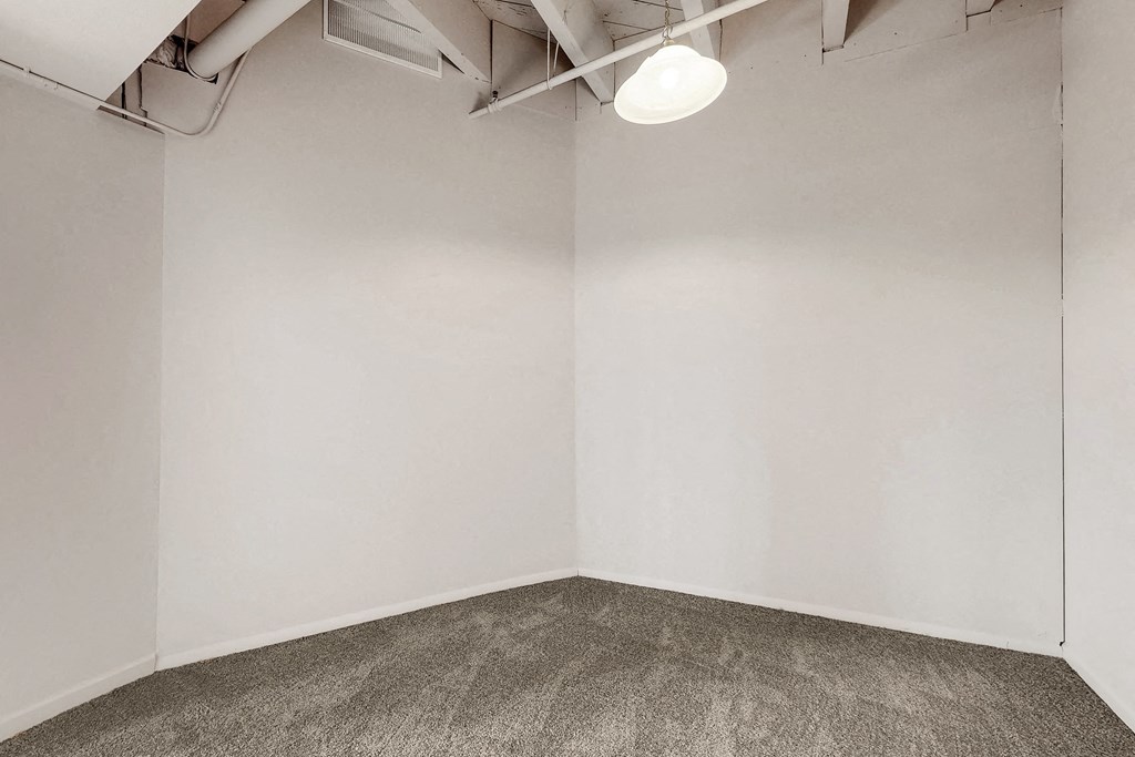 an empty room with a carpeted floor and a white wall