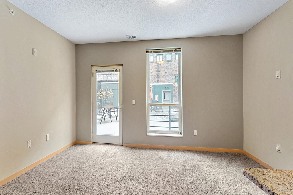an empty living room with a door to a patio