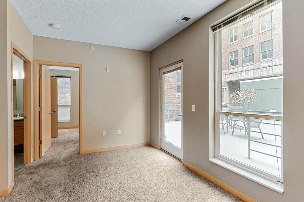 a living room with a large window and a door to a balcony