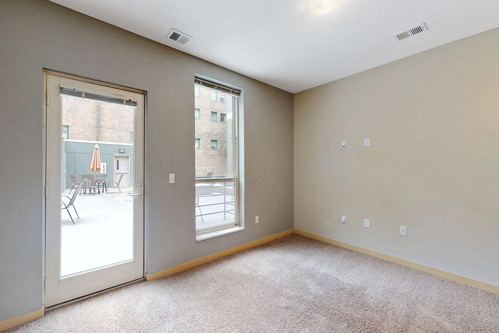 an empty living room with a sliding glass door to a patio