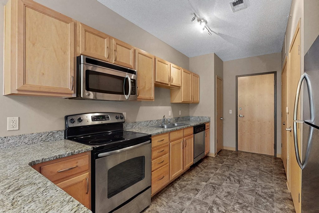 a kitchen with stainless steel appliances and wooden cabinets