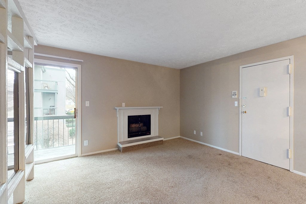 a living room with a fireplace and a door to a balcony