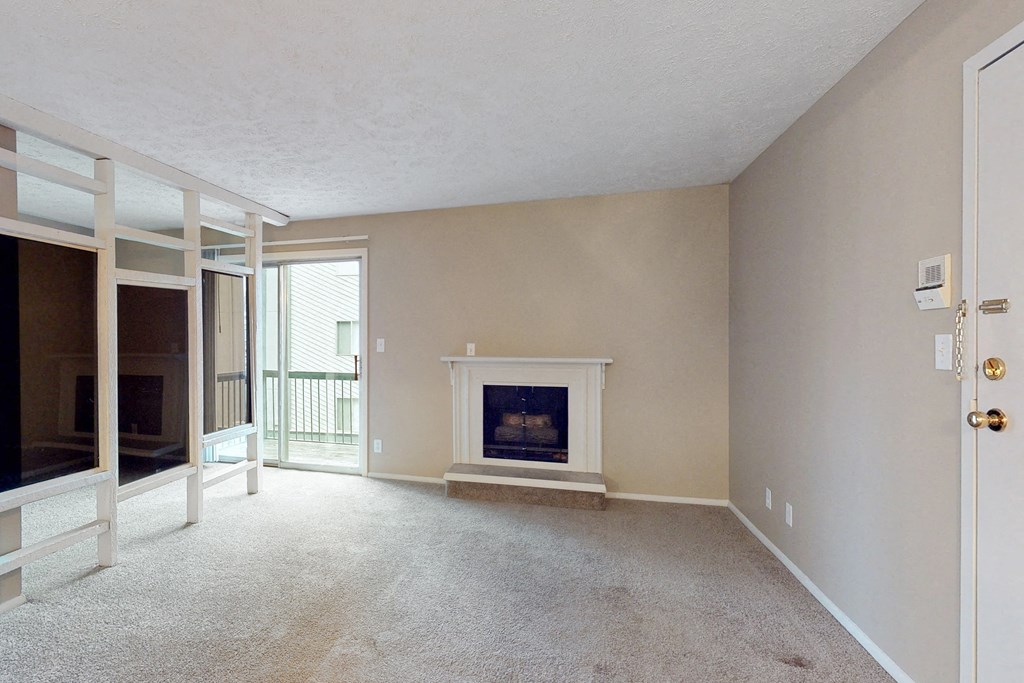 an empty living room with a fireplace and a sliding glass door