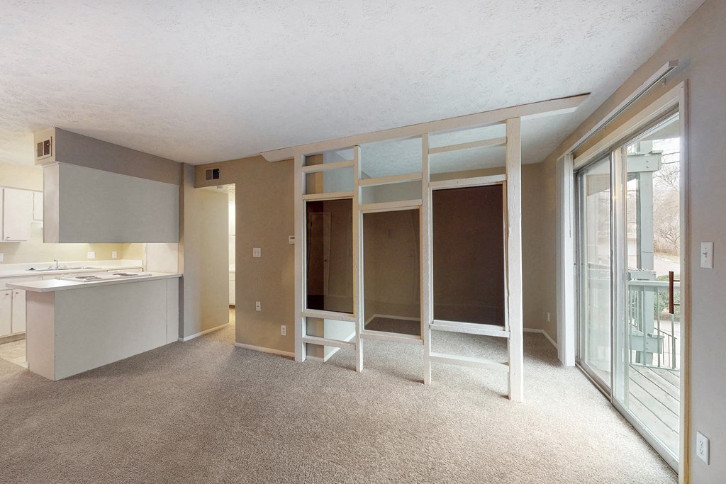 a living room with a kitchen and sliding glass doors