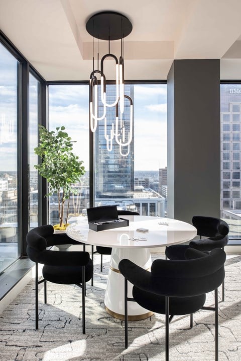 a round white table with black chairs in a room with floor to ceiling windows  at 220 Meridian, Indianapolis, IN, 46204