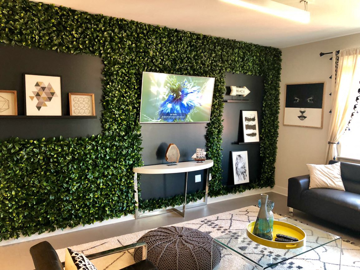 a living room with a green wall covered in ivy