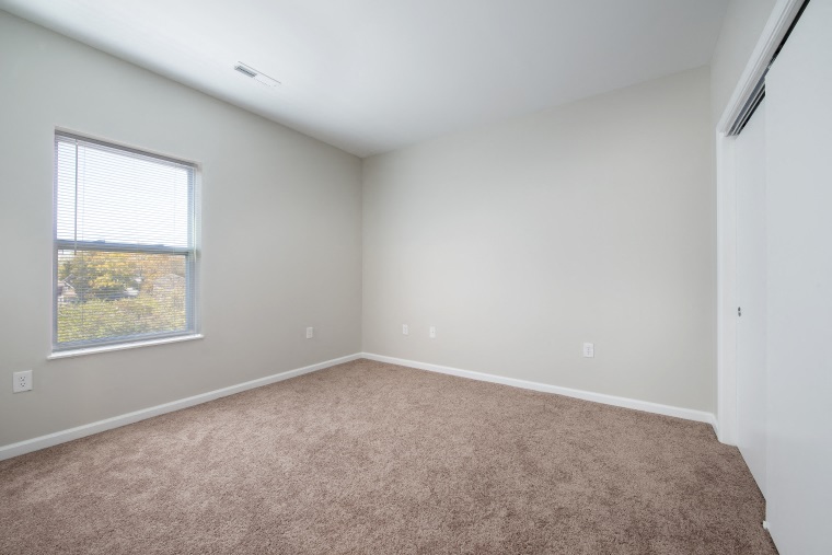an empty room with carpet and a window