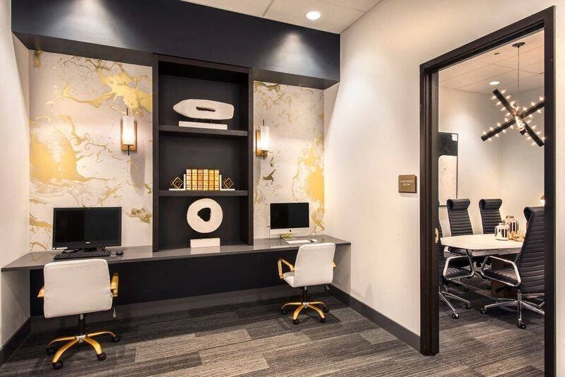 a conference room with two desks and chairs and a mirror