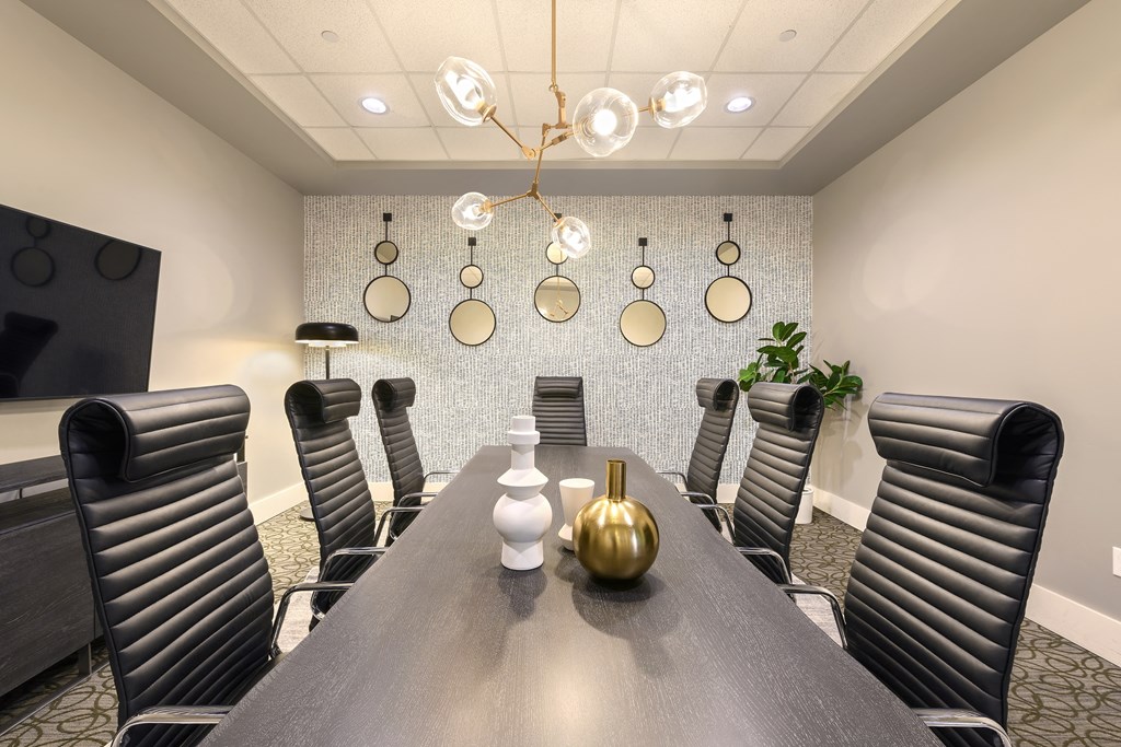 a conference room with a long table and chairs and a chandelier