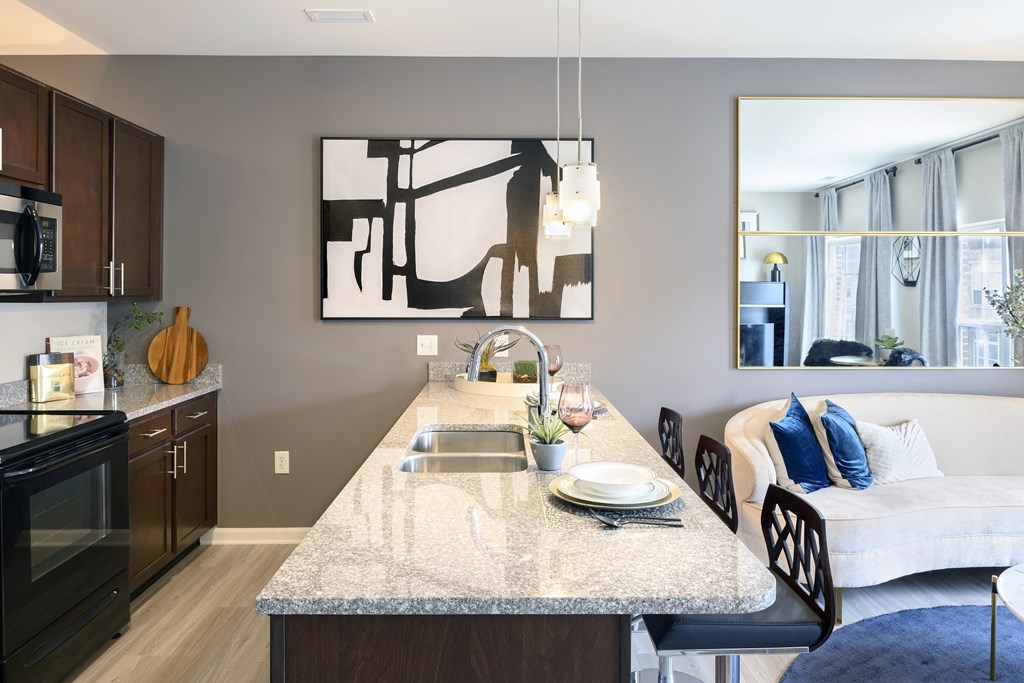 an open kitchen and living room with a marble counter top