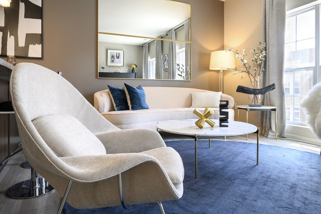 a living room with a white couch and chair and a table