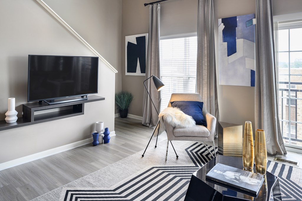 a living room with a tv and a chair and a rug