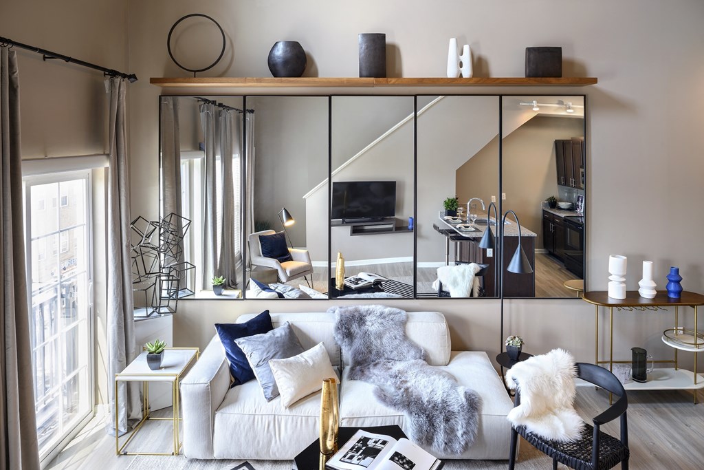 a living room with a white couch and a large mirror