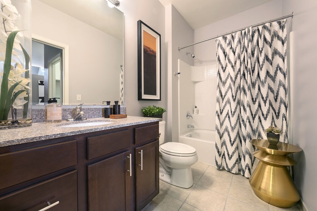 a bathroom with a shower and a sink and a toilet