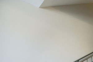 the upstairs corridor of a building with stairs and a door