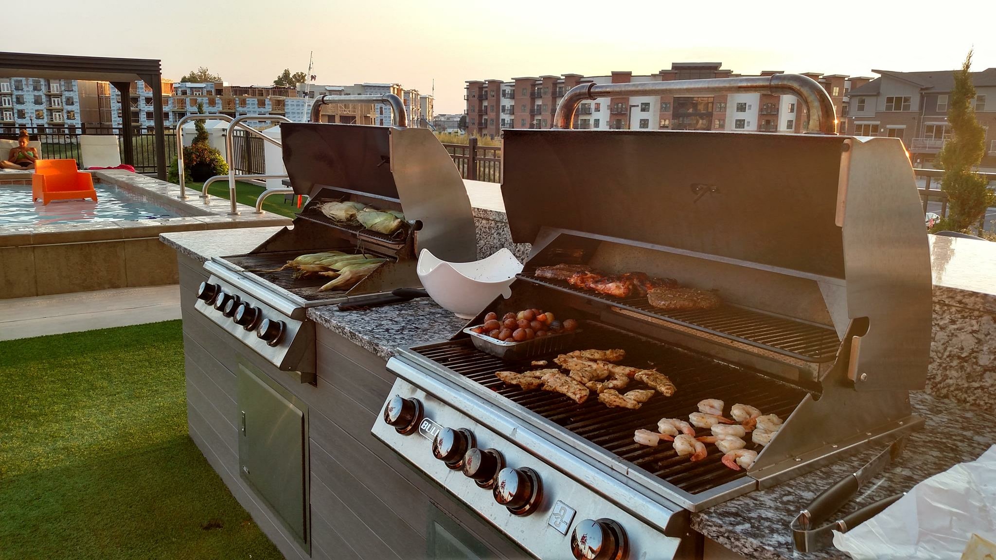 a barbecue grill with food on it on a rooftop