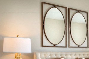 a bedroom with a bed and two mirrors above it