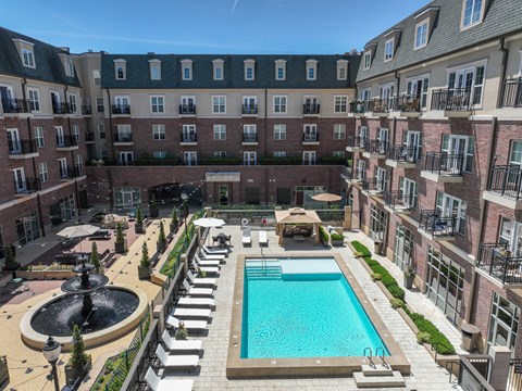 A large pool surrounded by a fence and a building in the background at Sophia Square Apartments, Carmel, IN