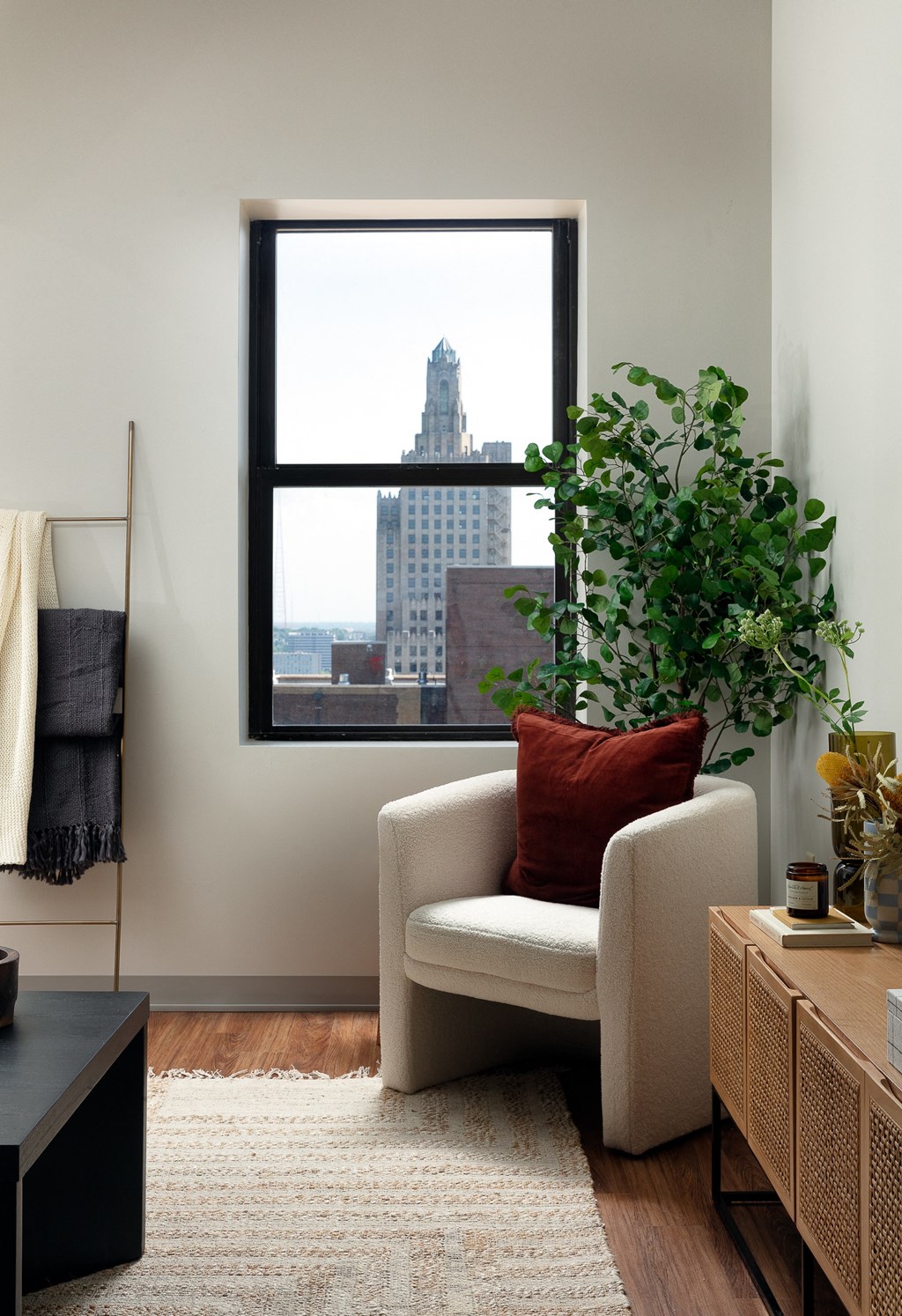 a living room with a chair and a window with a view of the city