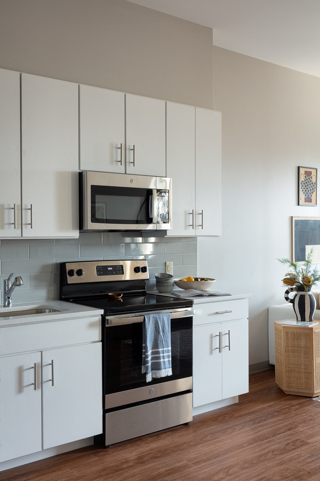 a white kitchen with stainless steel appliances and a microwave