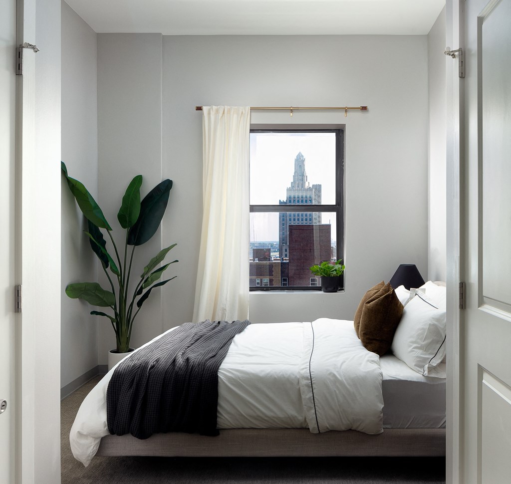 a small bedroom with a bed and a window