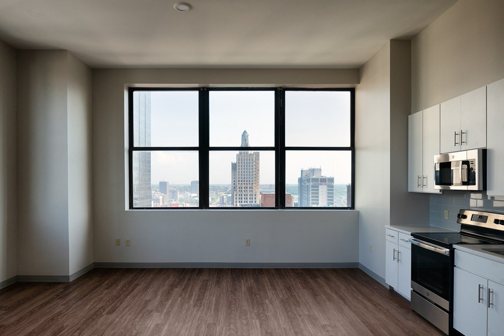 an empty kitchen with a large window and a city view