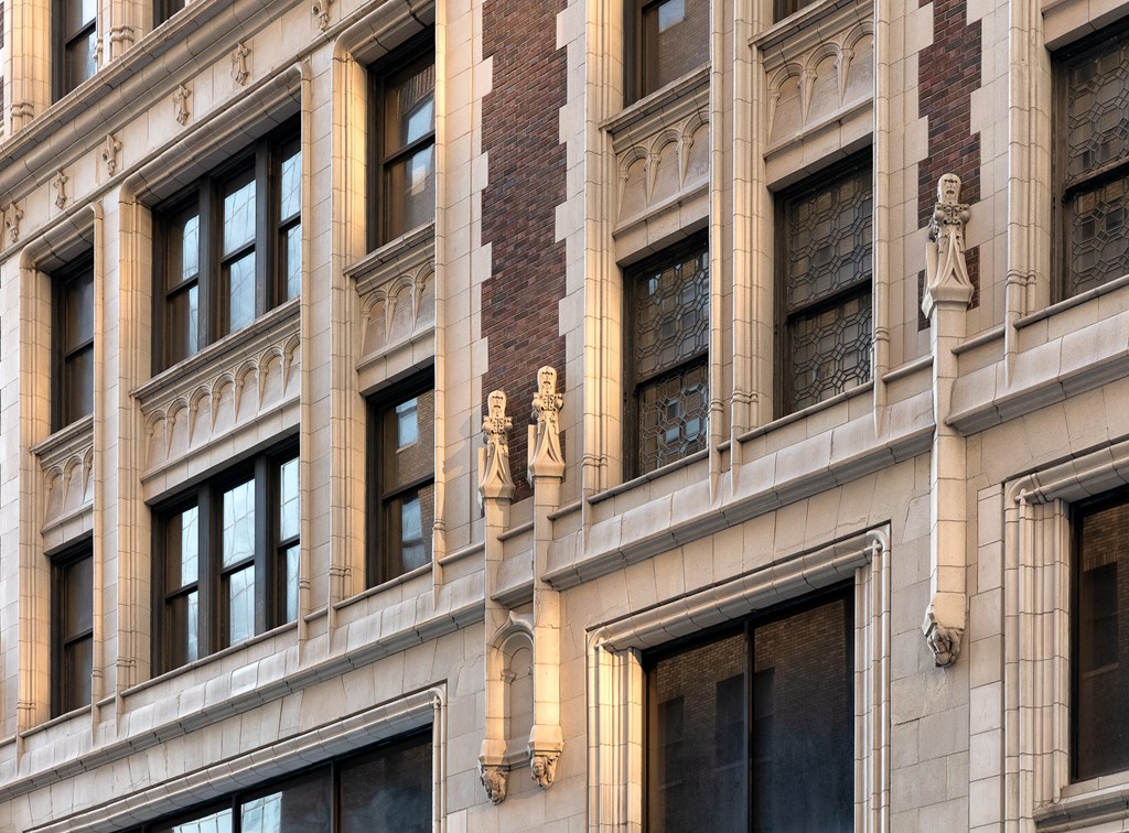 the facade of a large building with windows and statues on it