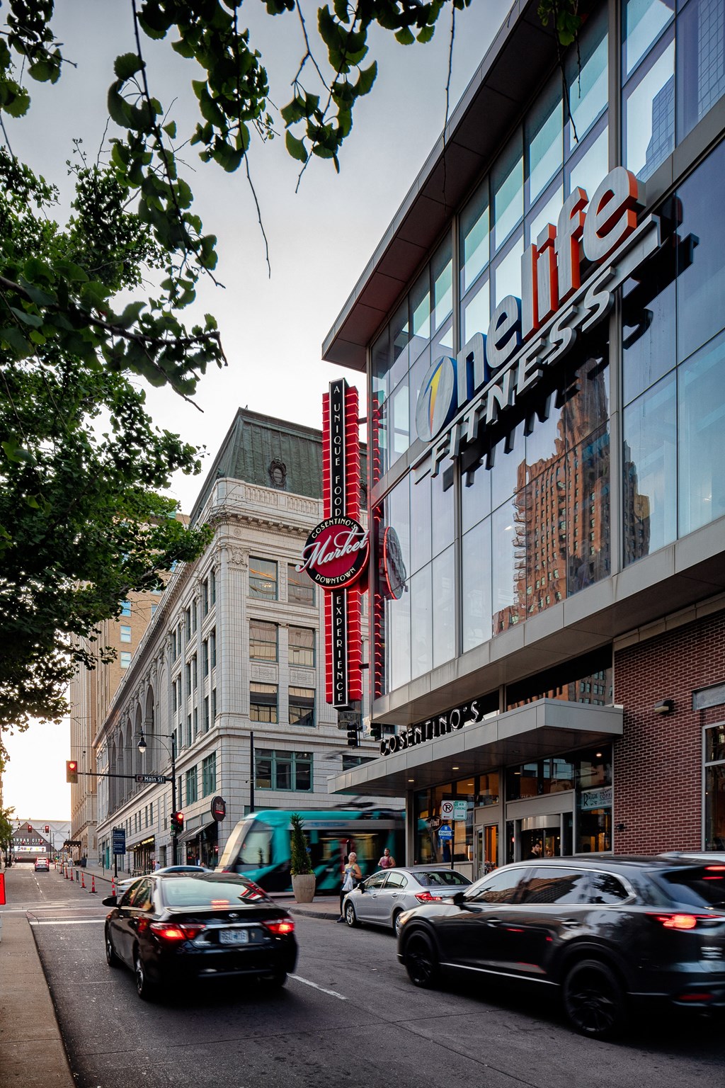a city street with cars driving past a building with a large sign on the side