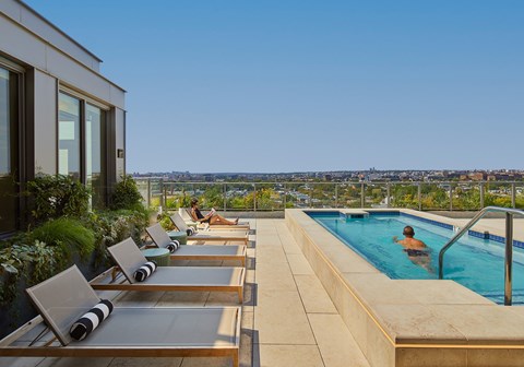 A person is sitting in a pool on a sunny day.