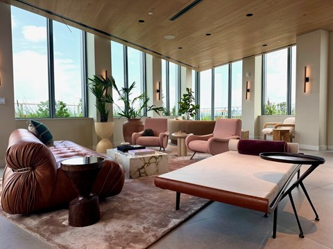 A living room with a brown leather chair and a brown ottoman.