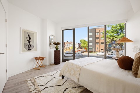 a bedroom with a bed and a large window