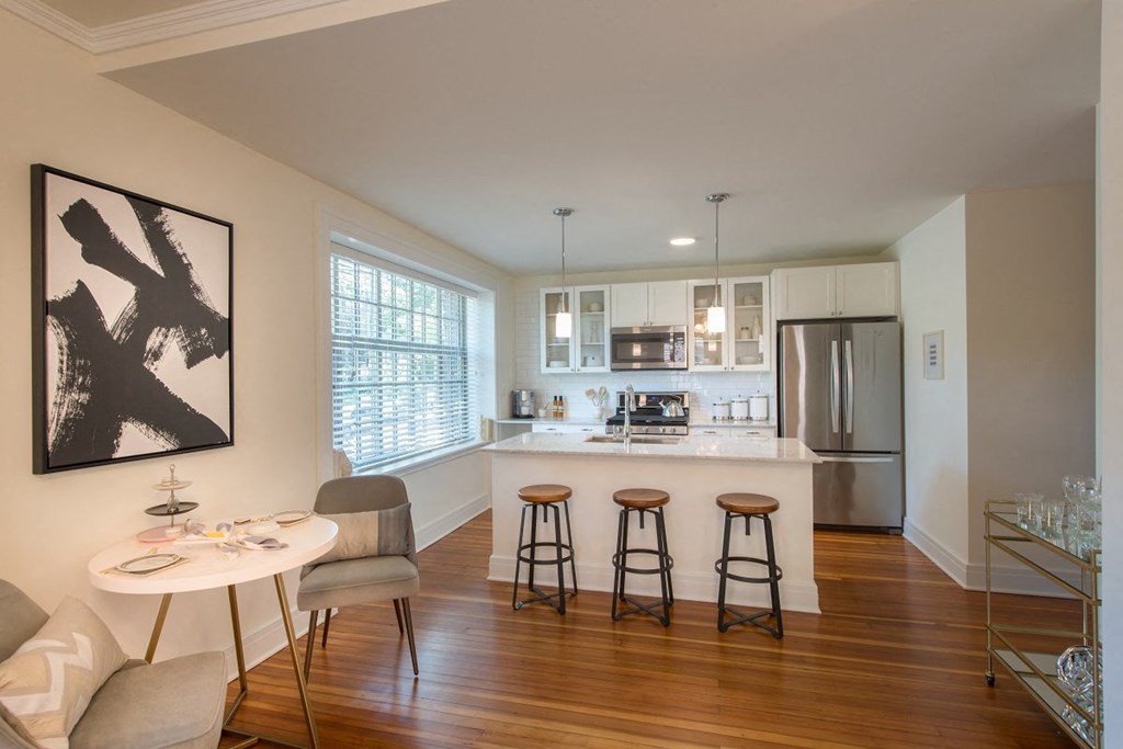 an open kitchen and dining area with a bar and stools