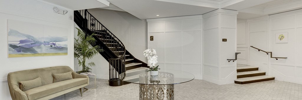 a living room with a staircase and a glass table