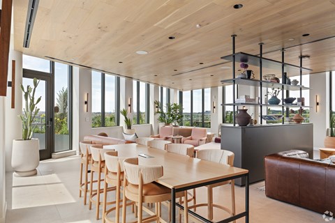 A modern dining room with wooden chairs and a long table.