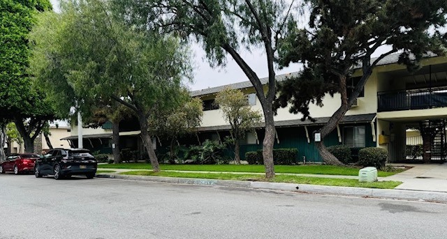 A building sits behind a row of trees.